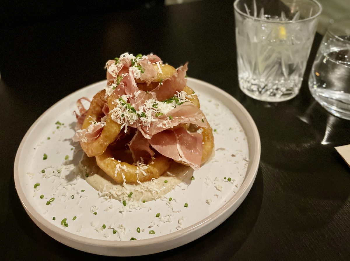 A white plate with onion rings and jamon