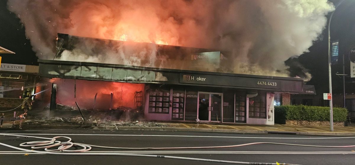 A burning commercial building at night, seen from the front