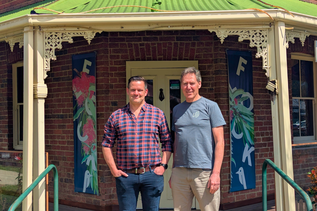 Two men standing in front of historic inn.