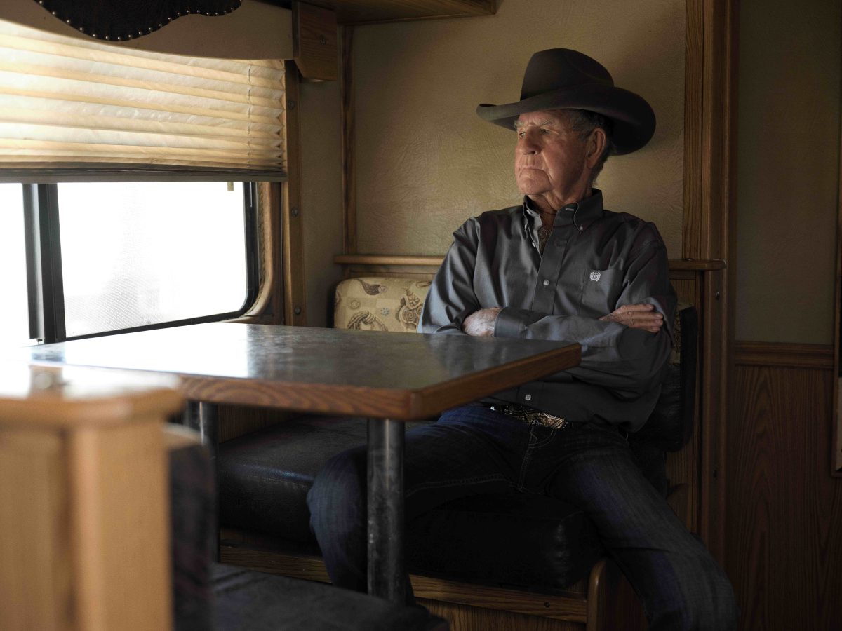 man wearing a cowboy hat and sitting at a dining table