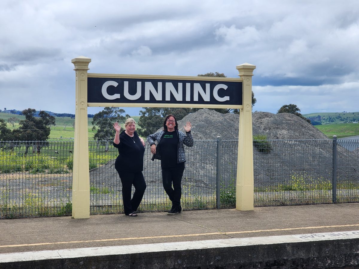 Two women in front of Gunning Railway Station sign