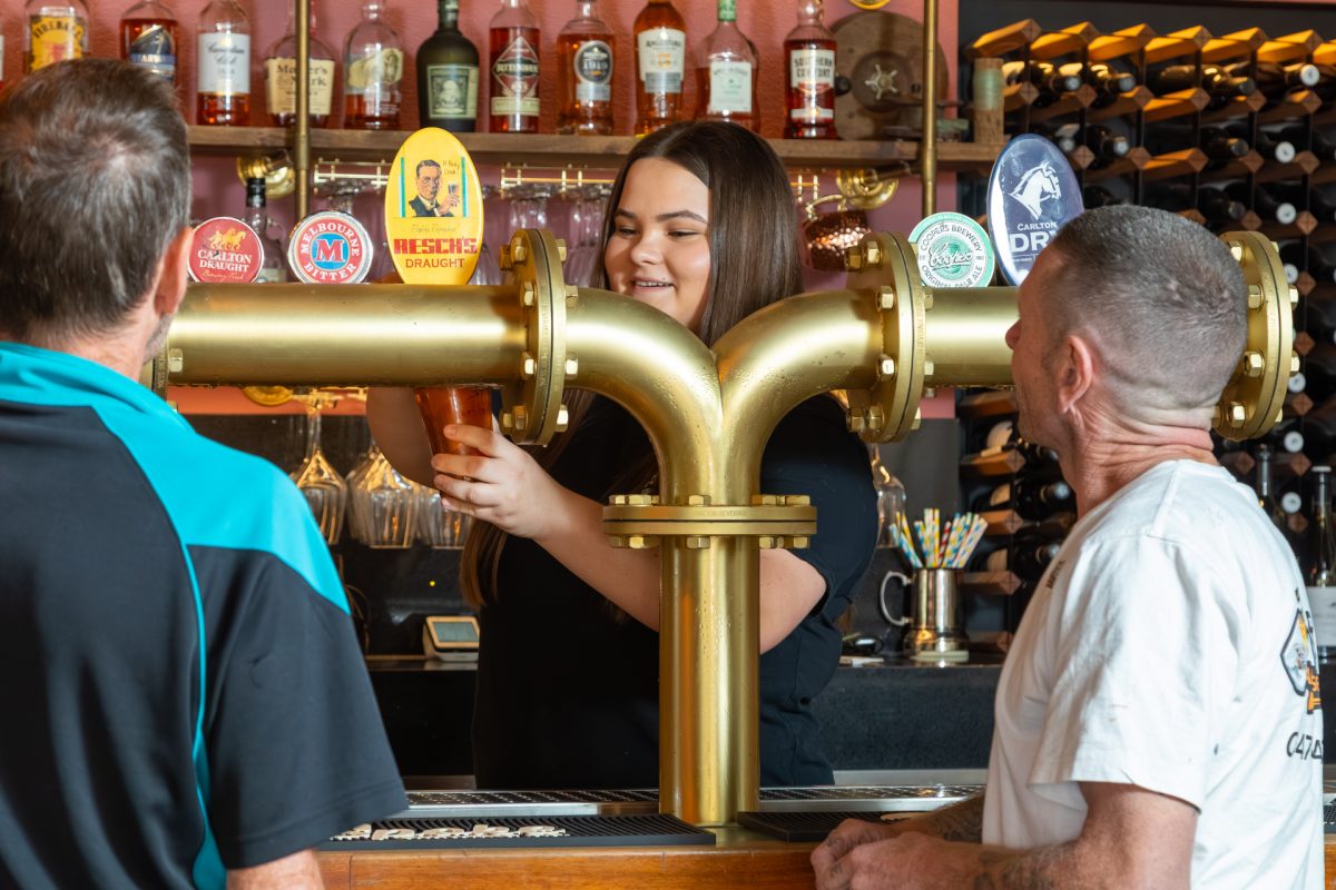 People standing at a bar waiting to be served drinks