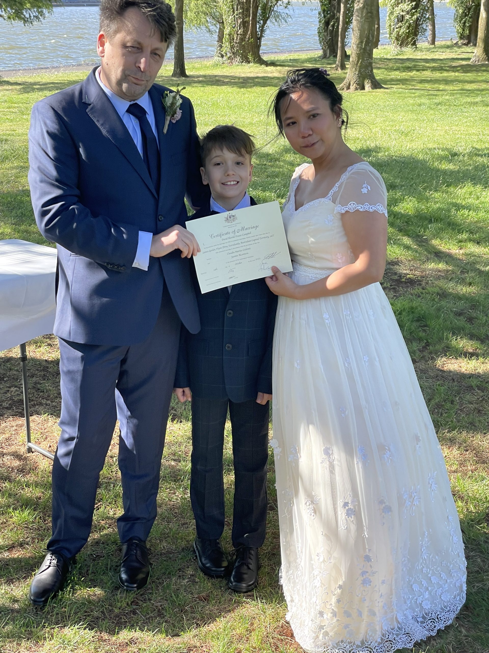 Man, woman and child hold their wedding certificate.