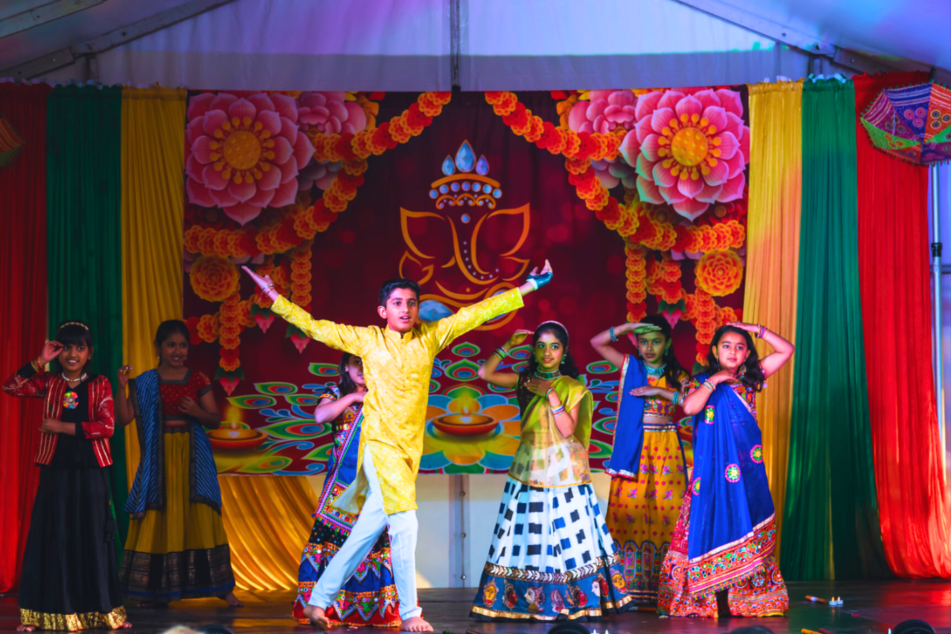 Performers on stage in traditional Indian attire.