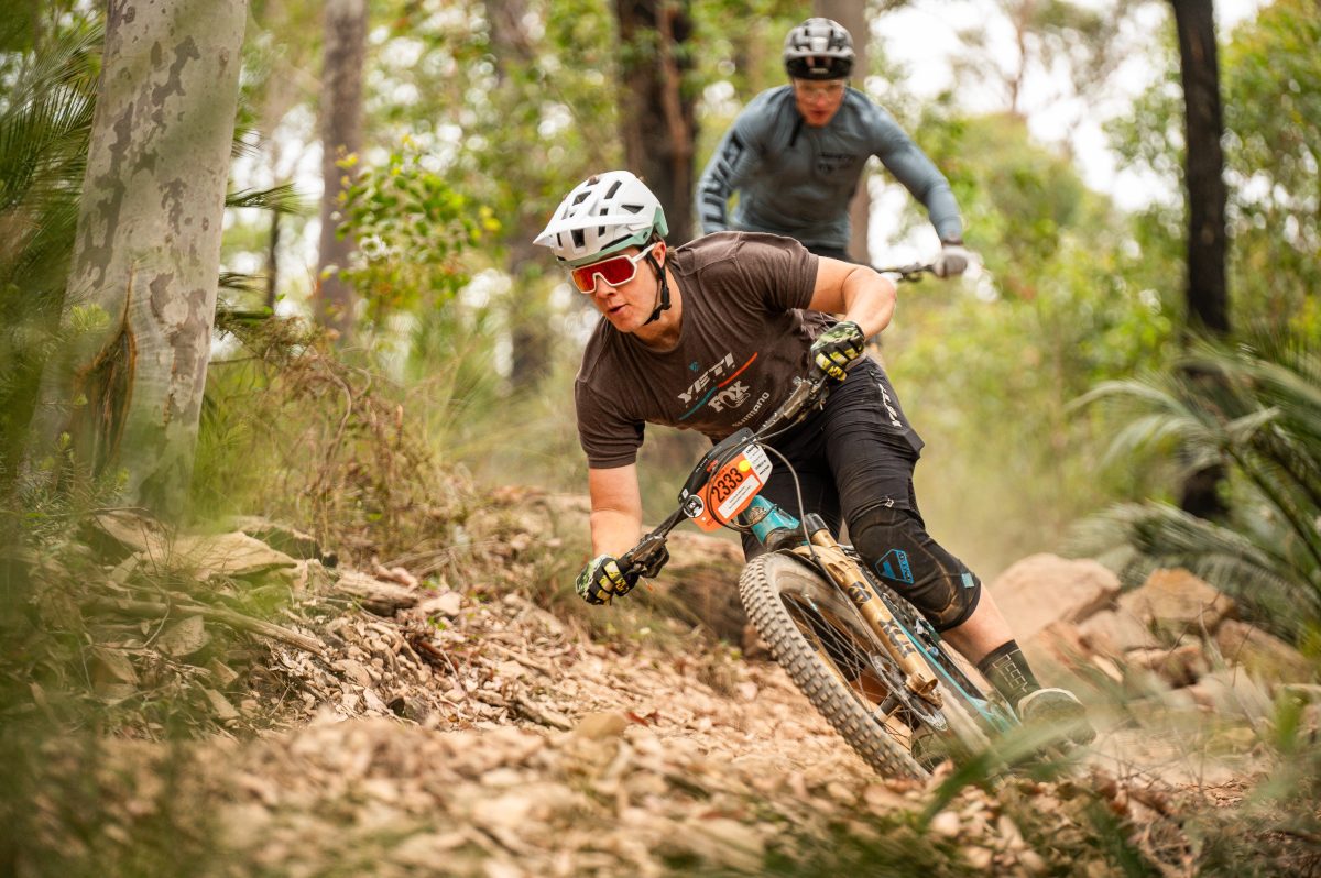 Two mountain bike riders riding through a course in the bush