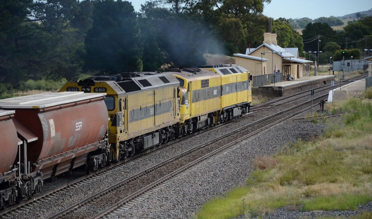 a southbound train powering through a small town's station