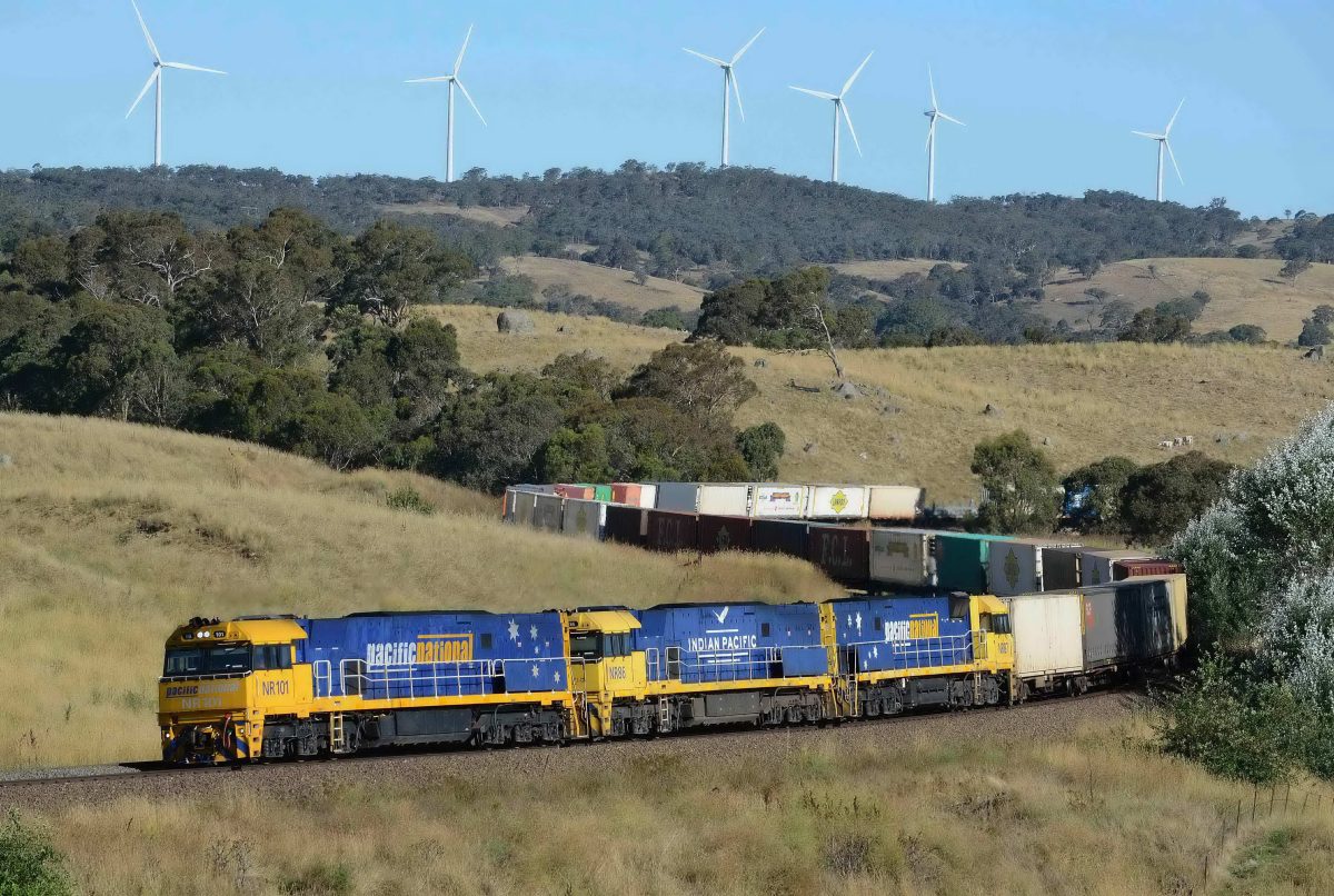freight train winding its way down a series of chain radius curves in a mountain range