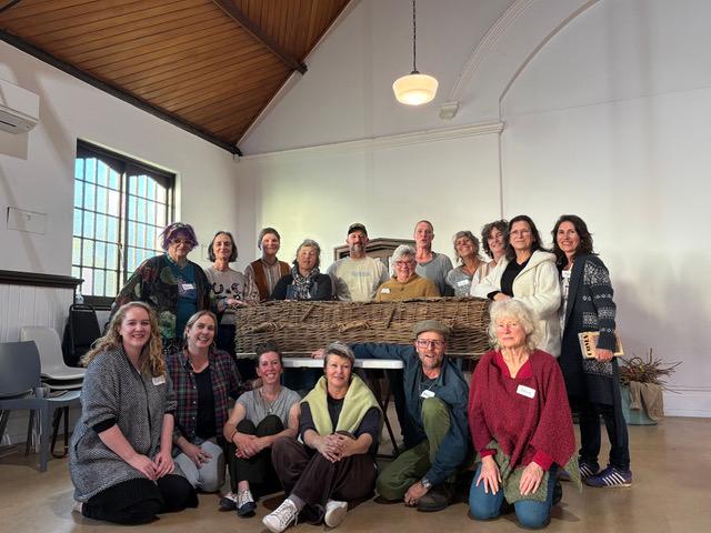 A group of people with a completed coffin.