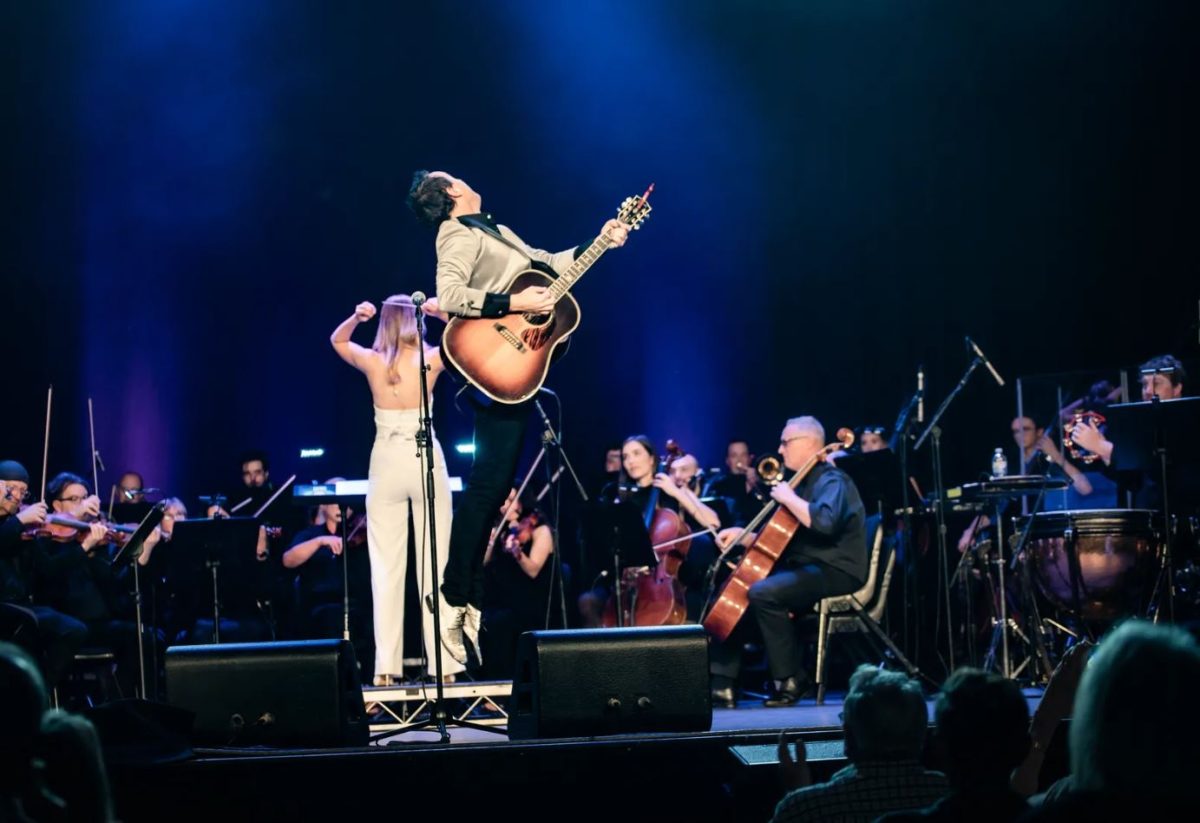 man singing in front of an orchestra