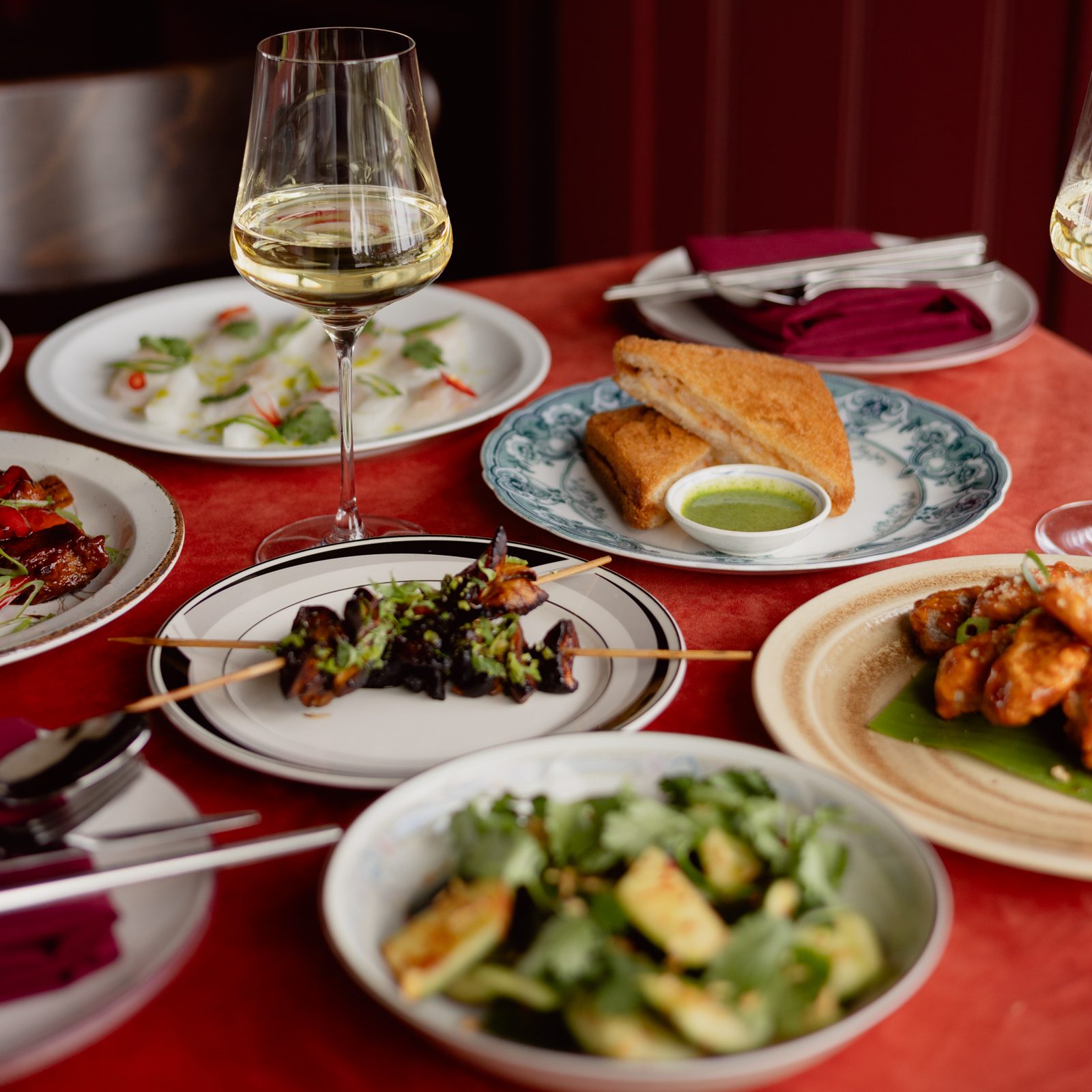 A table set with many dishes and glasses of wine. 