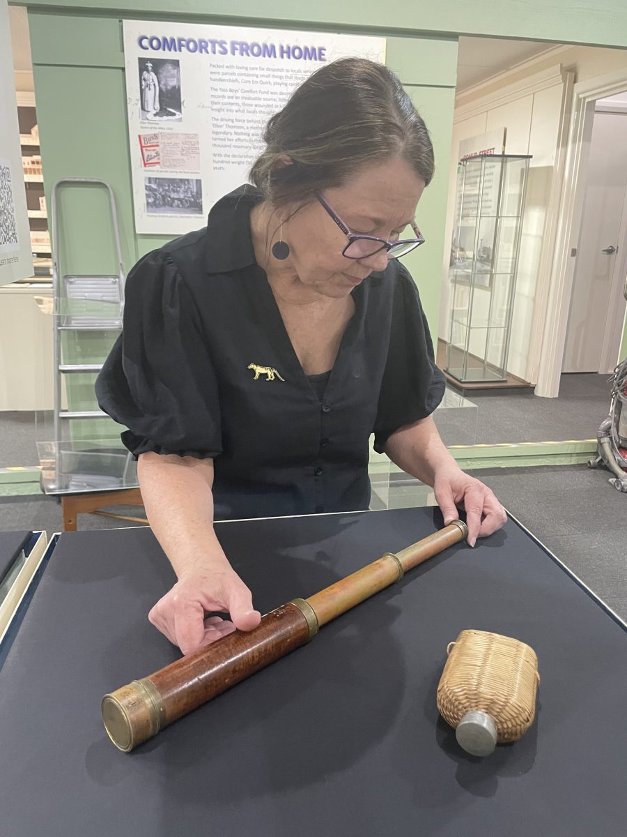 Woman looking at old telescope and drink bottle