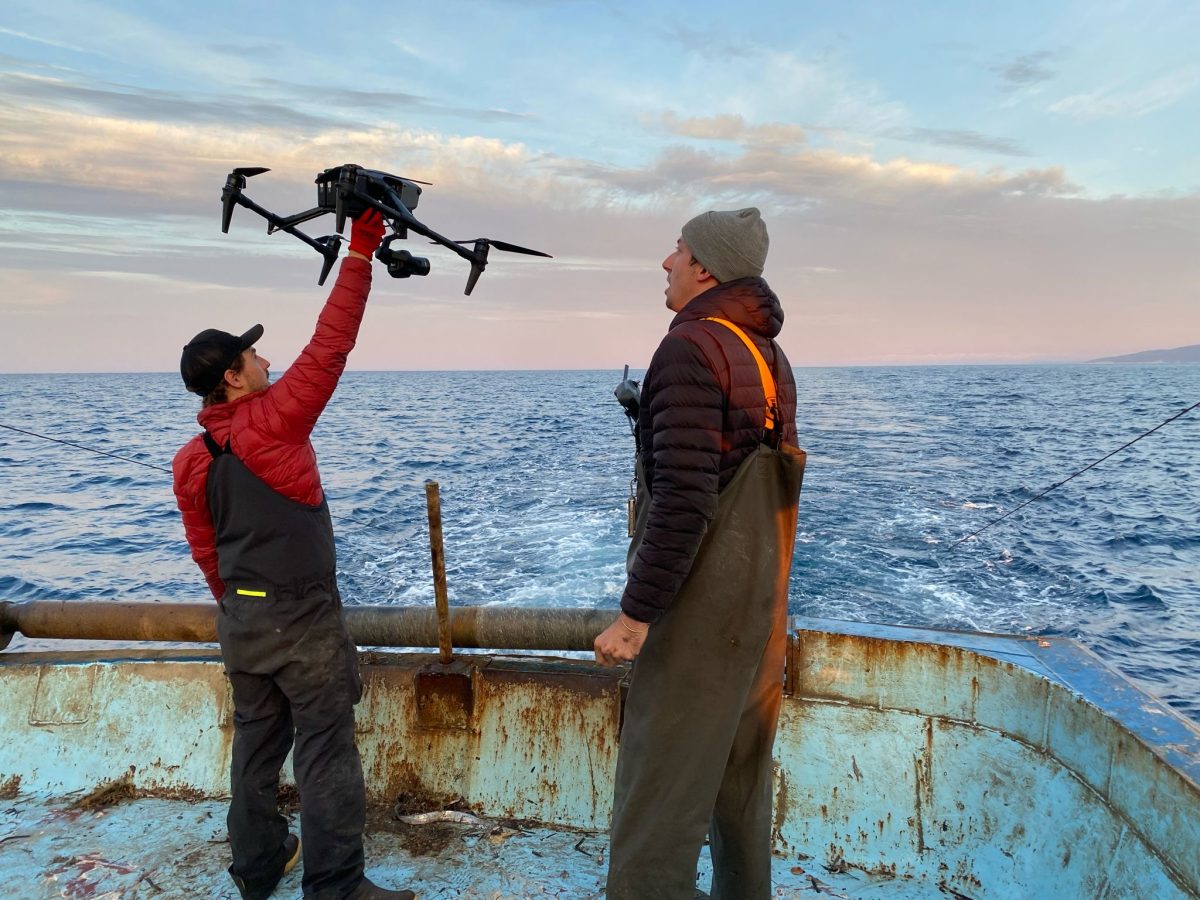 two men launching a drone from a trawler