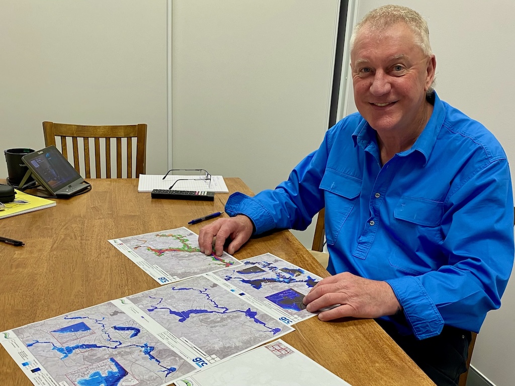 man looking at flood maps at a desk