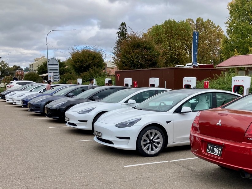 parked row of Tesla electric cars on charge