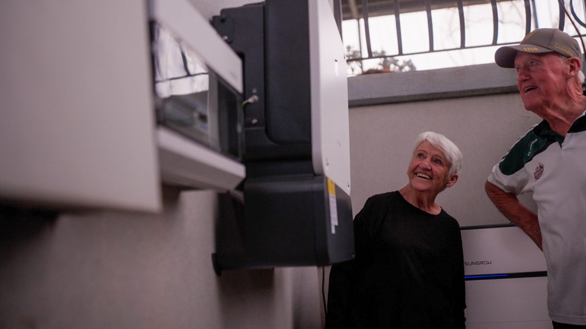 An elderly couple looking at their home battery