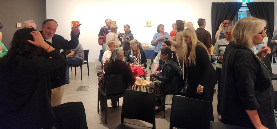 Crowd in art gallery talking and mingling