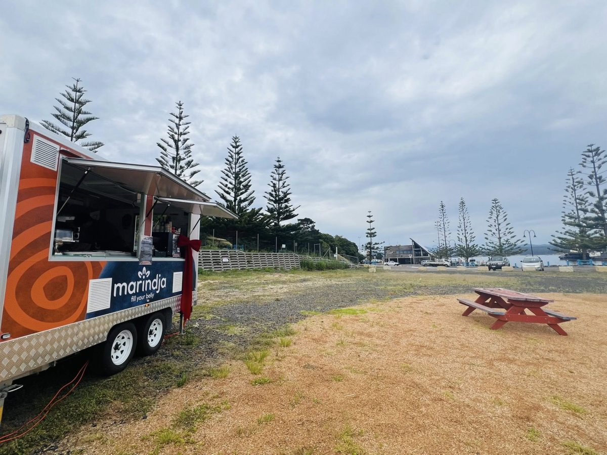 A food truck set up outdoor near seating