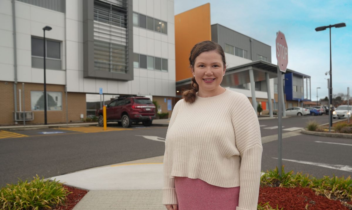 A smiling woman standing in front of Queanbeyan Hospital