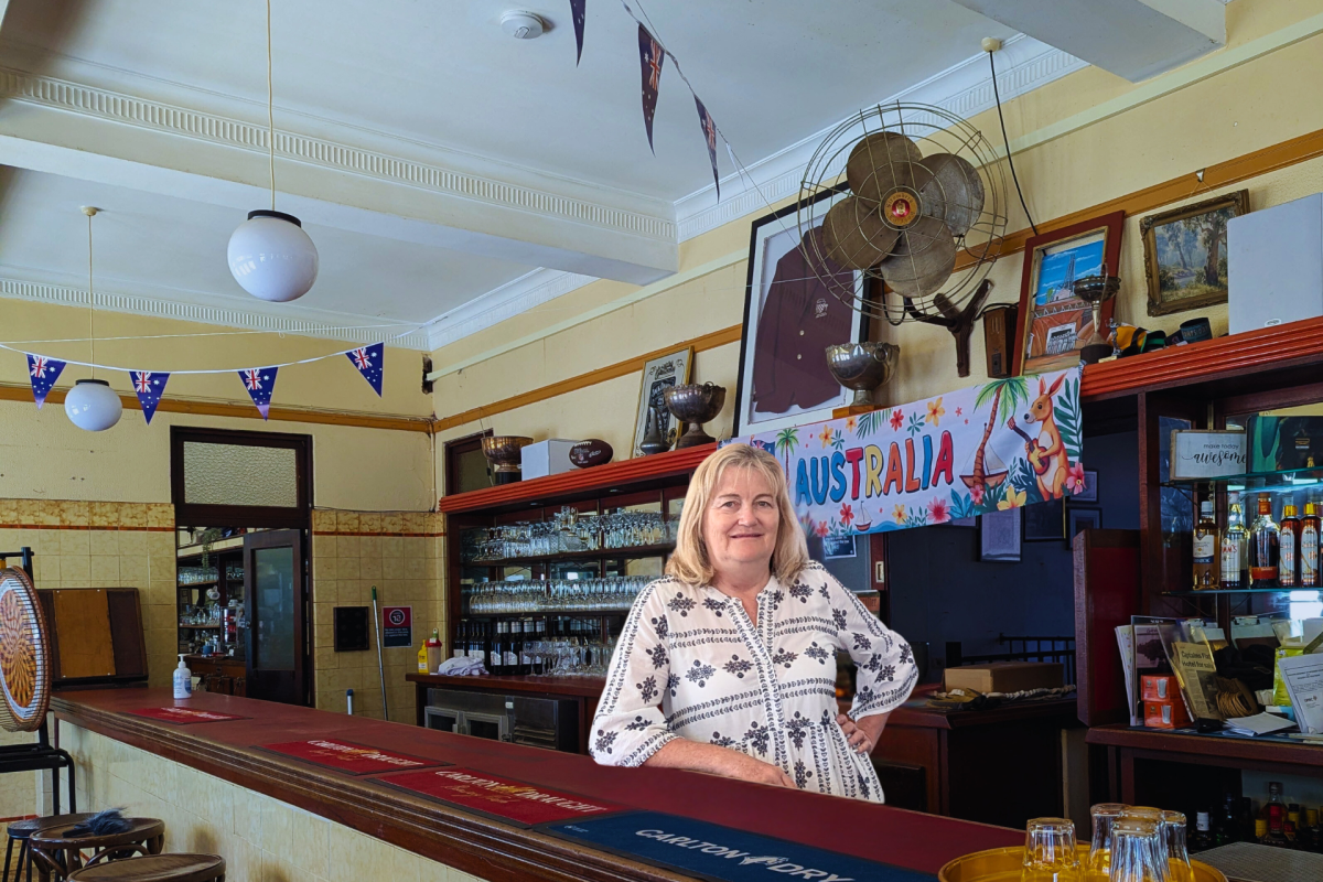 Woman stands behind bar