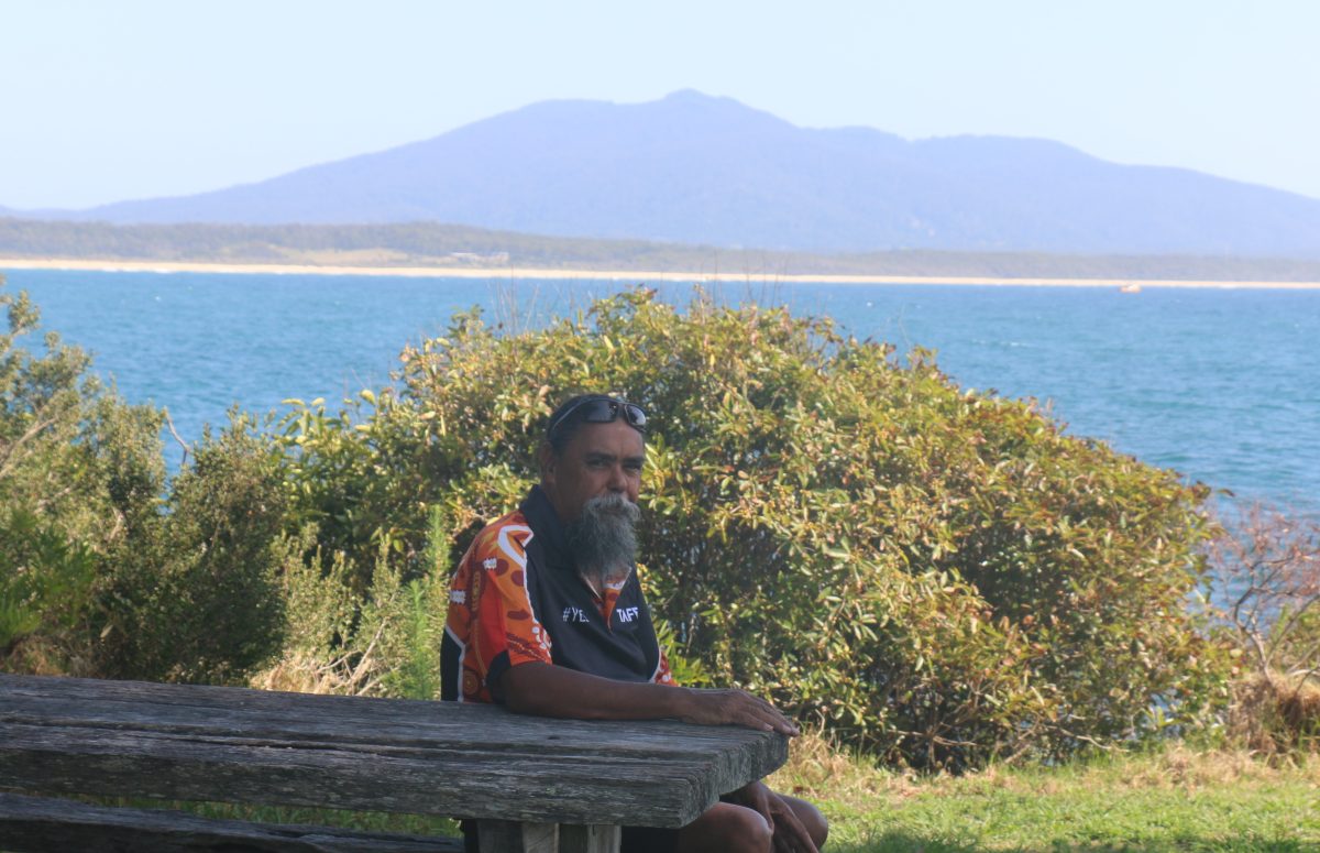 man sitting at a table by the sea