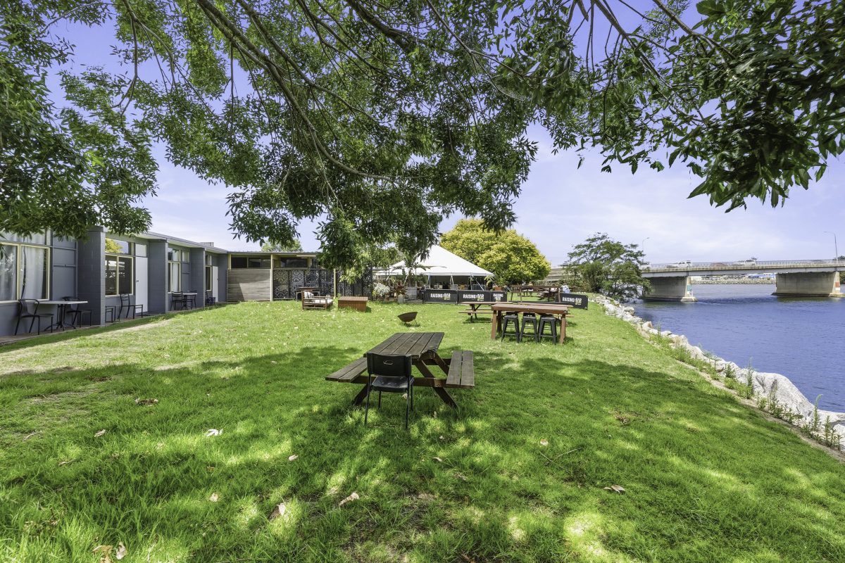 The outside of the hotel, showing outside seating near the river