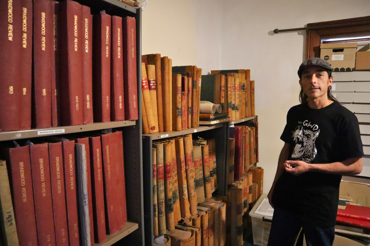 Man stands in room with historic books.