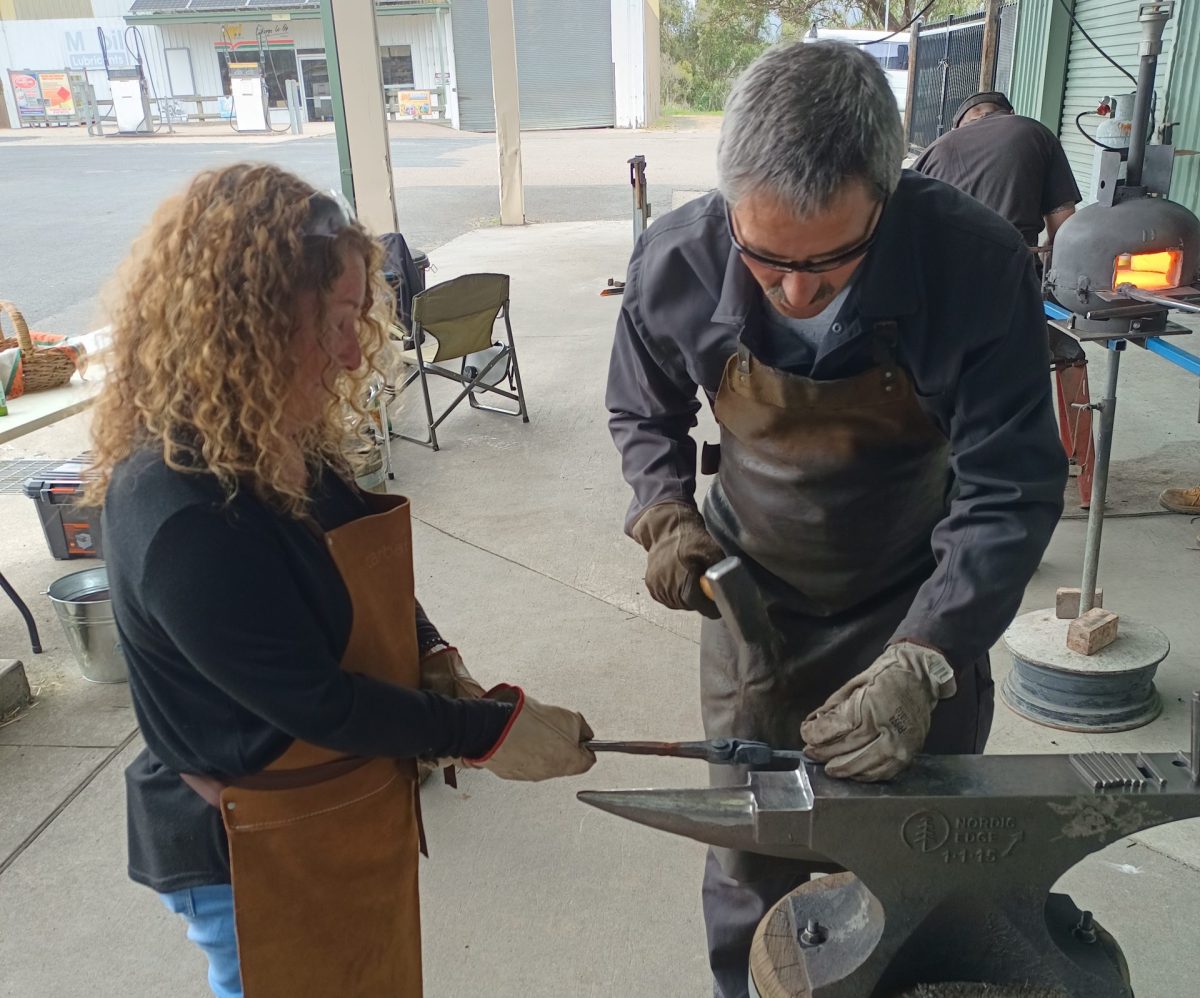 Philippe Ravenel of Galba Forge stamps a community member's name on a leaf.
