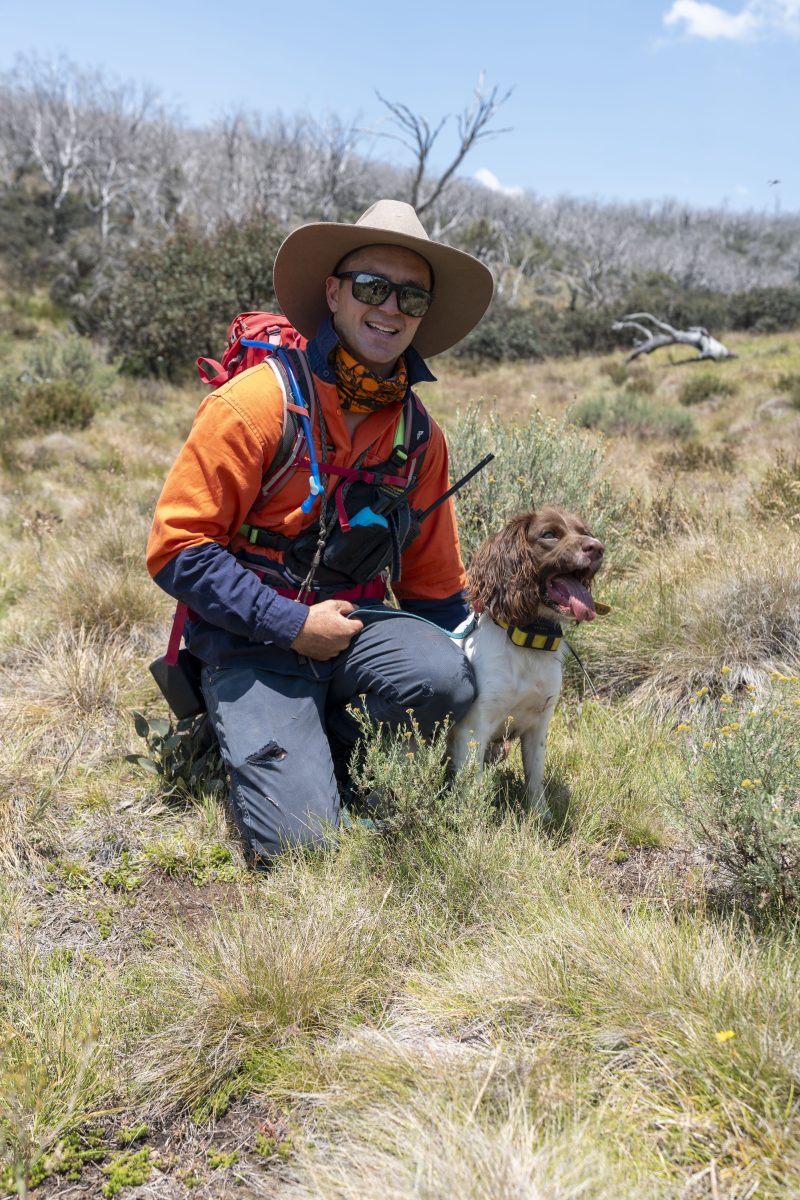 A man kneeling next to a dog