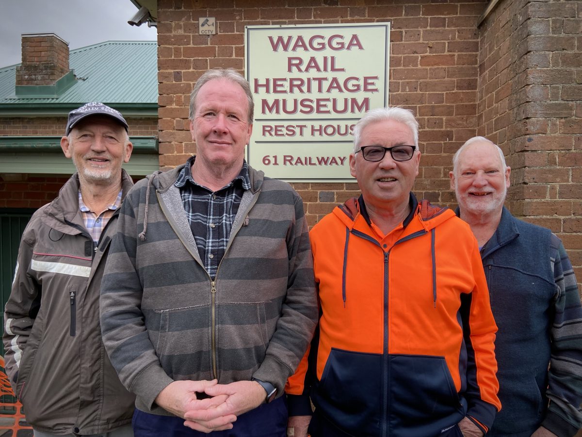 four men in front of a Wagga Rail Heritage Museum sign