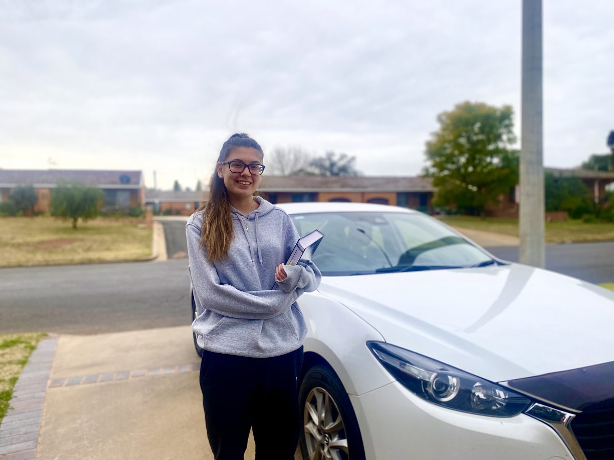 Emily in front of car