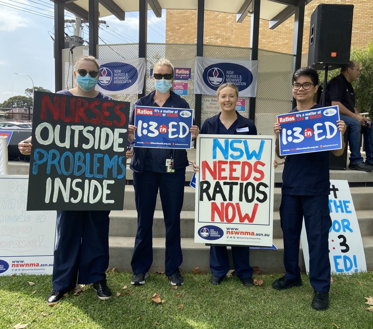 Four nurses hold placards
