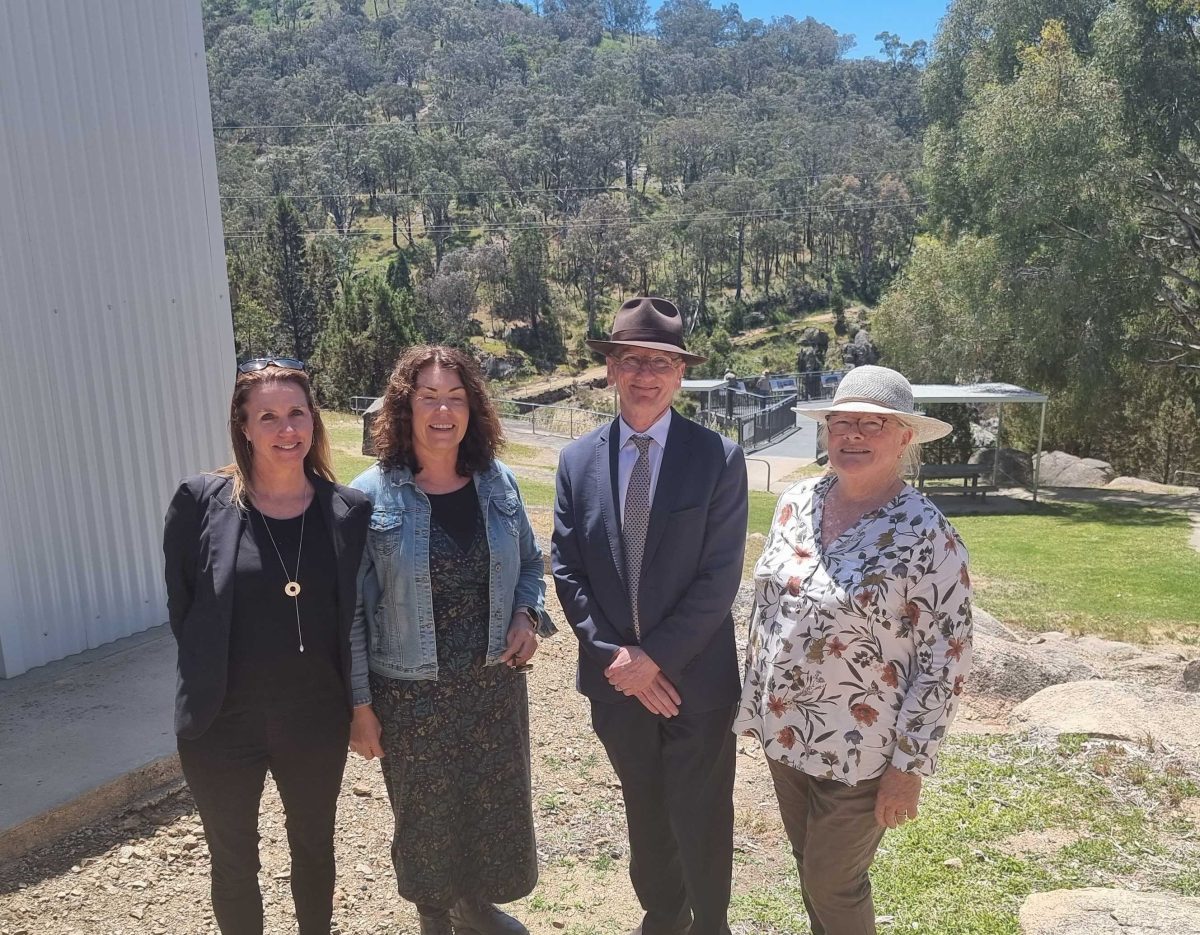 four people standing in the countryside