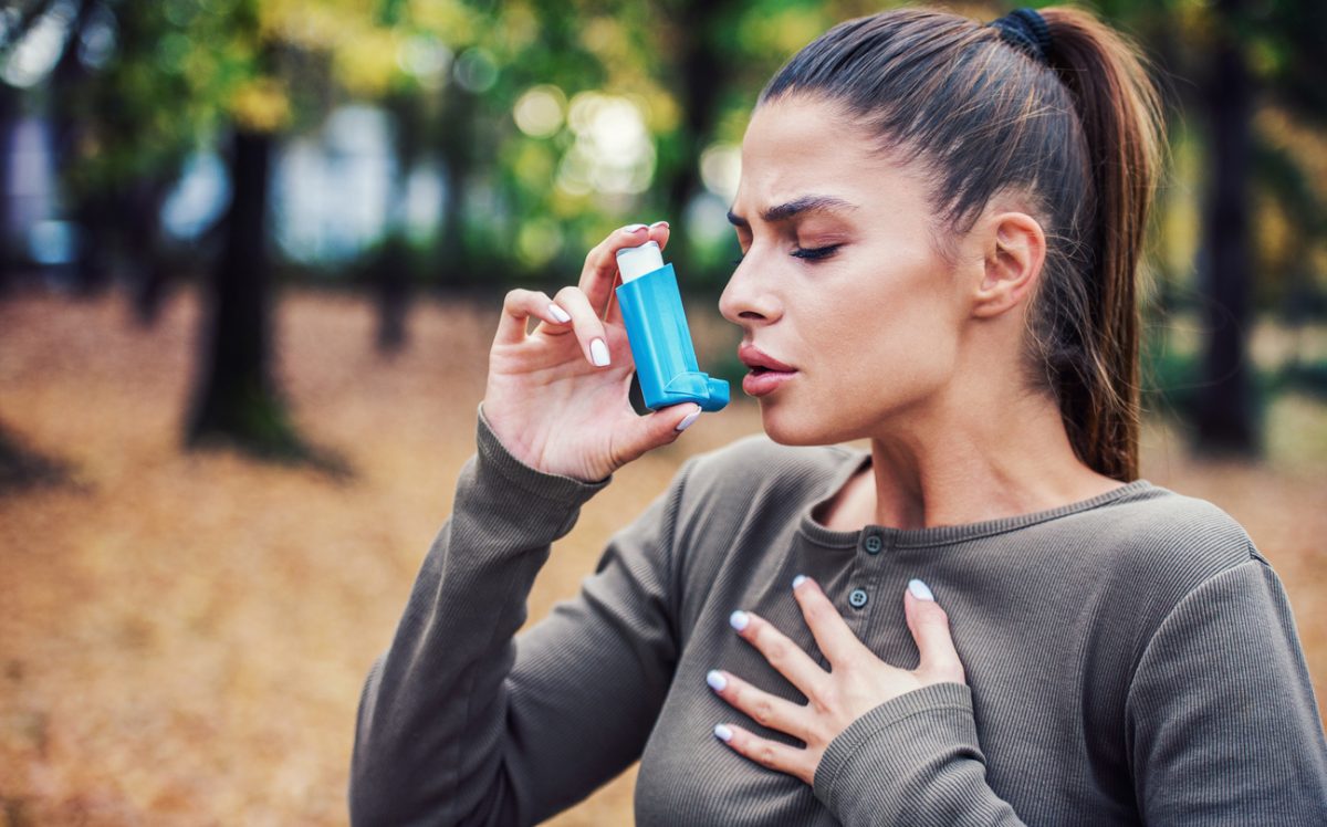 a woman using an asthma-relieving inhaler