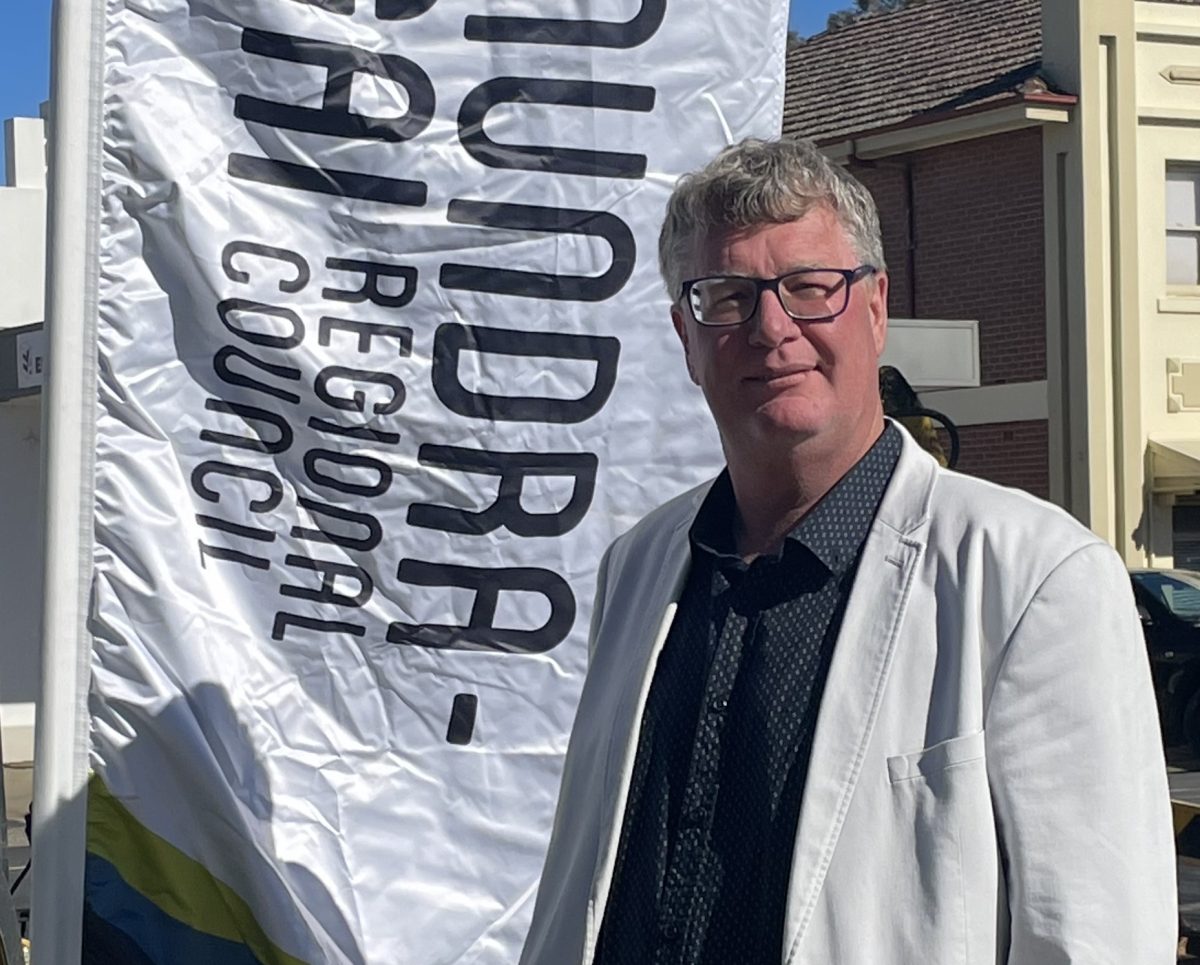 man standing in front of council banner