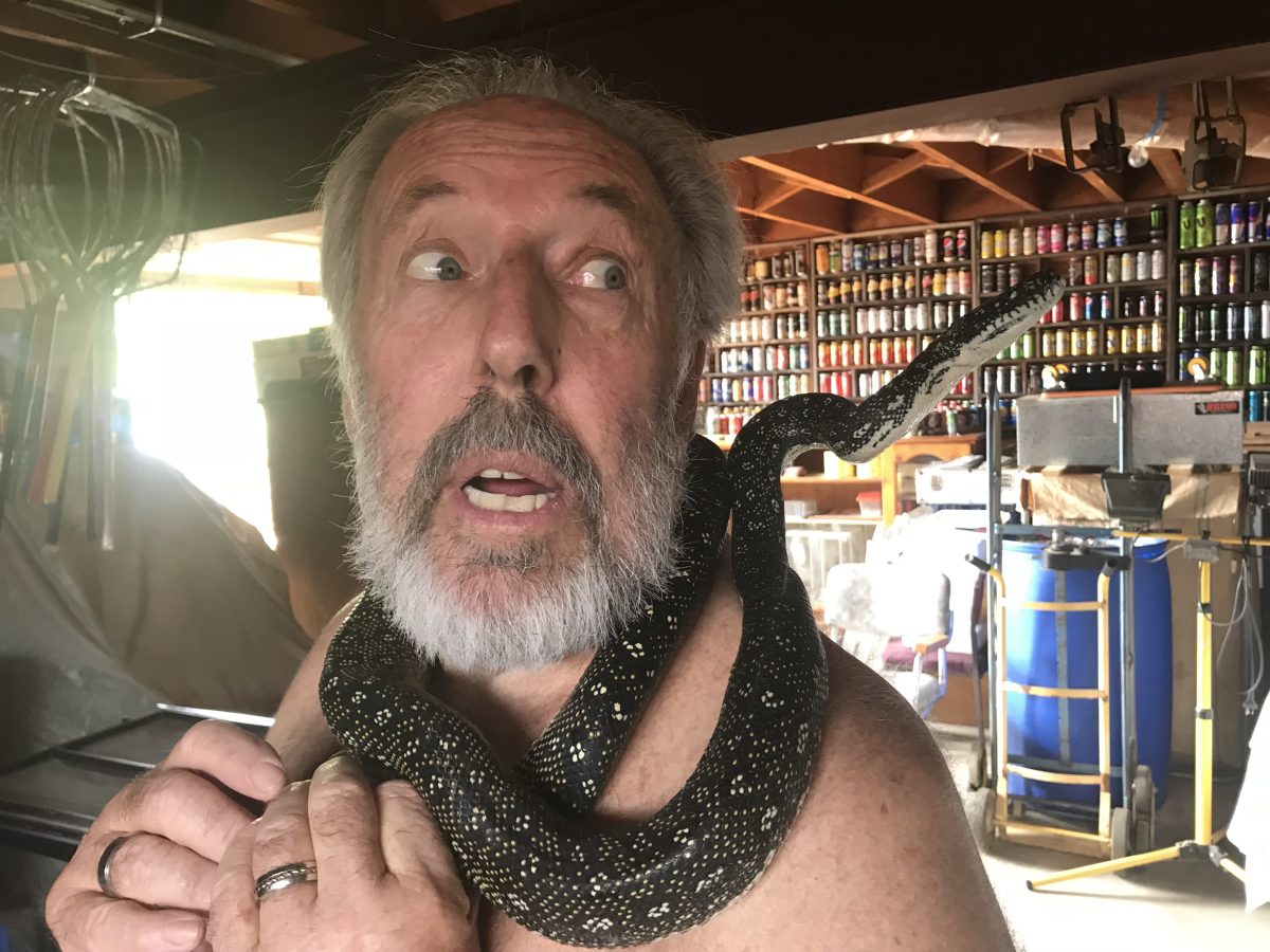 man with snake round neck